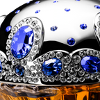 Decorative object with blue and clear gemstones on a reflective surface