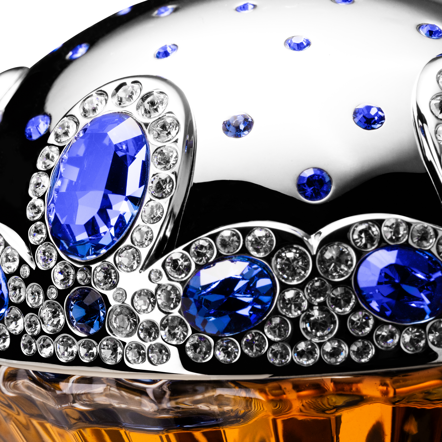 Decorative object with blue and clear gemstones on a reflective surface