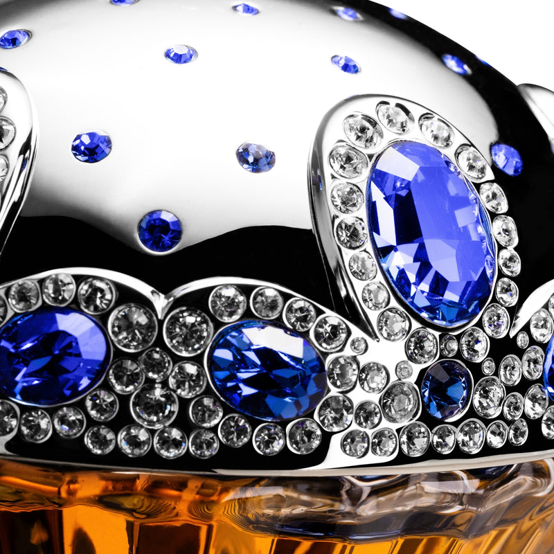 Decorative item with blue gemstones and silver accents on a reflective surface